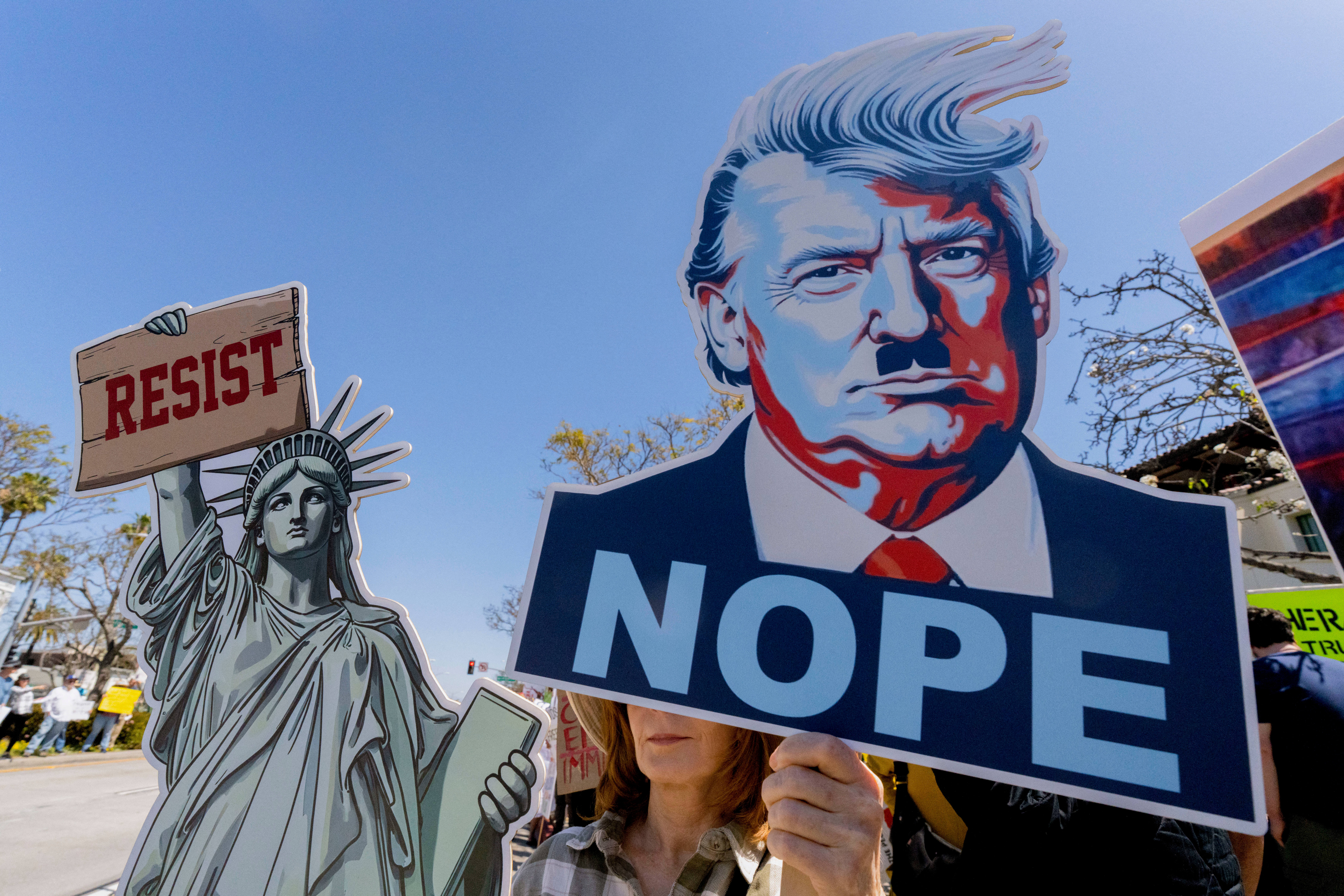 A protester in Los Angeles draws a comparison between Donald Trump and Adolf Hitler.