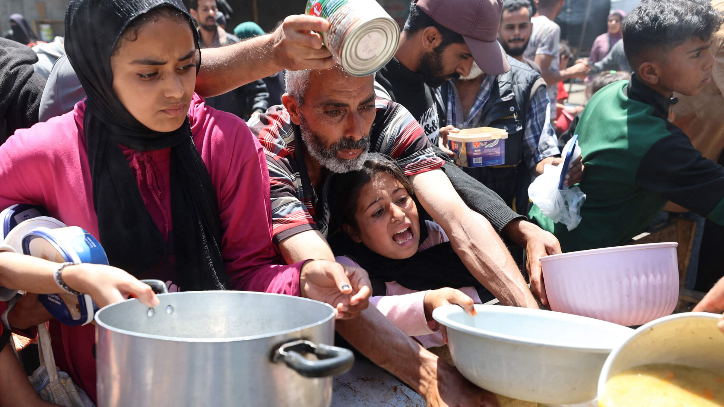 Palestinians wait for a meal at a charity kitchen at the Nuseirat refugee camp in the central Gaza Strip on May 4. 